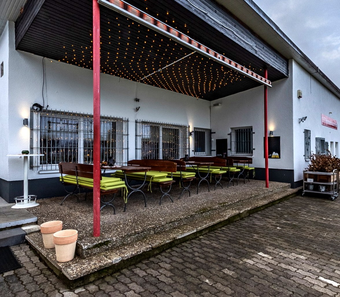 Überdachte Terrasse mit Lichtern im Tollus Restaurant